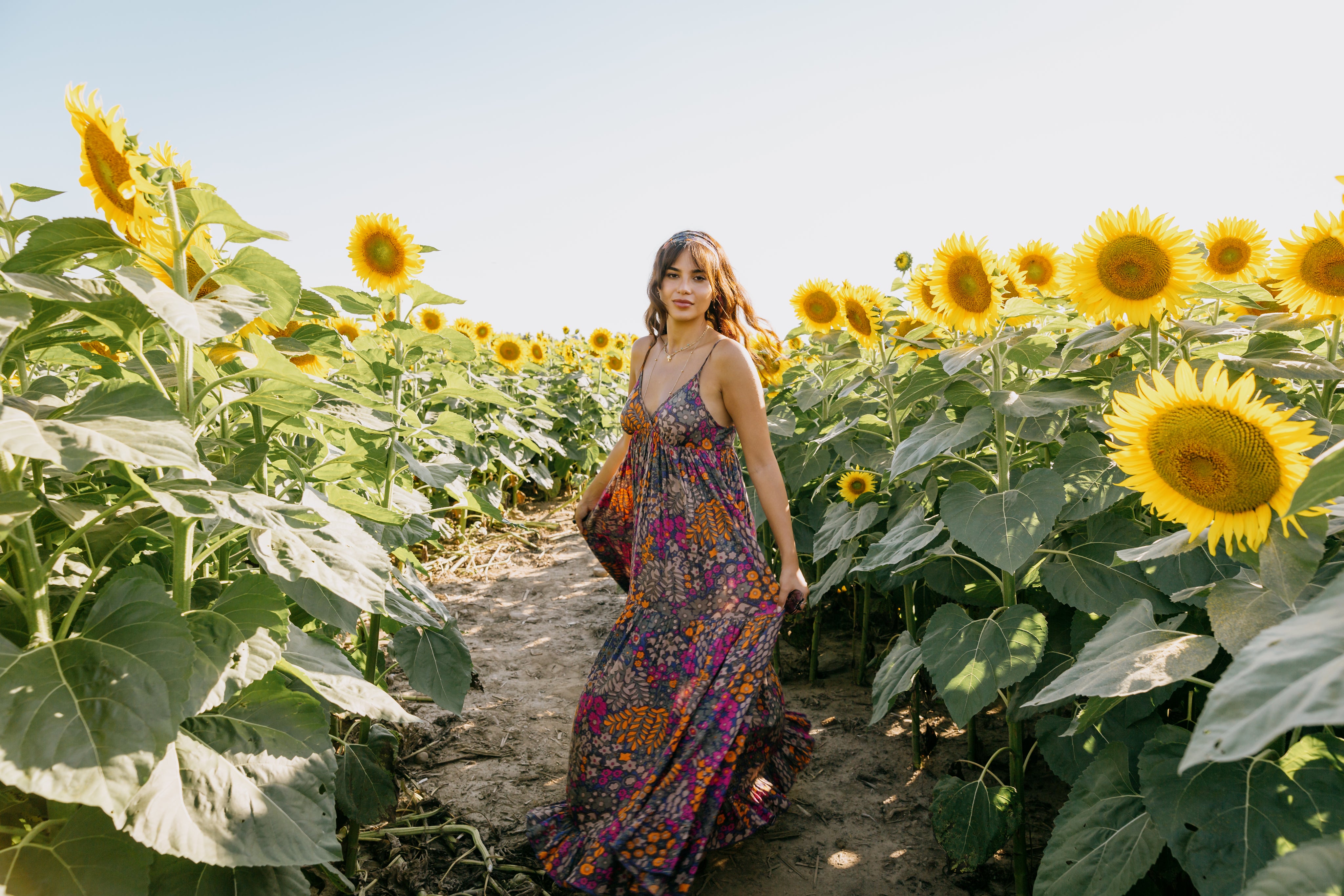 woman-in-a-floral-dress-stands-in-a-sunflower-field.jpg